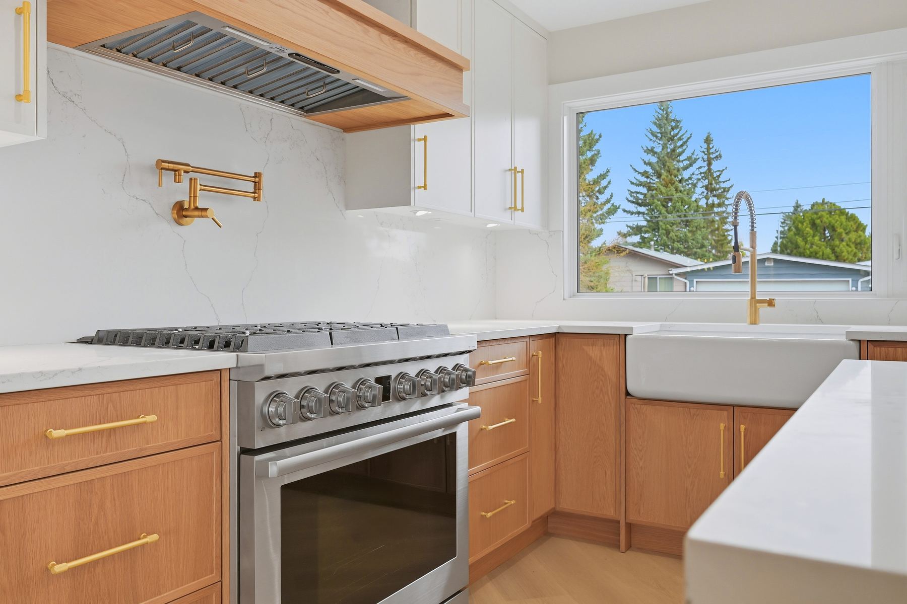 Range and brass pot-filler over quartz backsplash